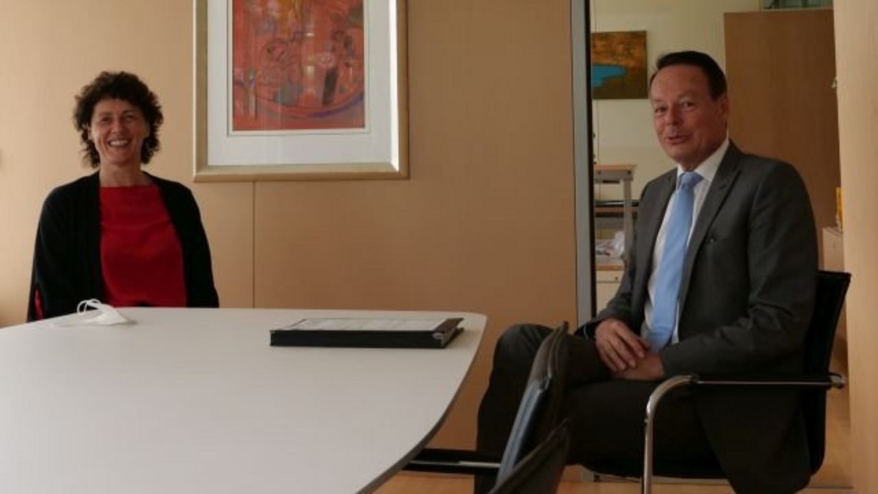 Anita Schmitt und Regierungspräsident Klaus Tappeser sitzen im an einem Tisch