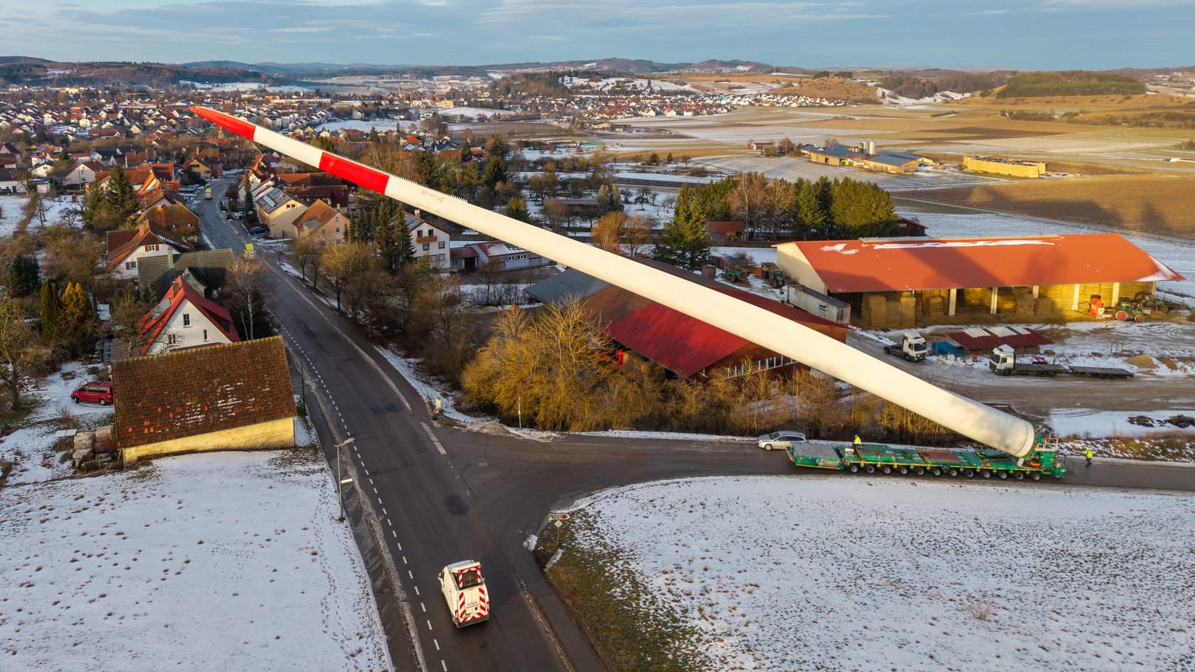 Blick von oben: Ein Schwerlasttransporter transportiert ein Rotorblatt durch enge Straßen in Gomadingen
