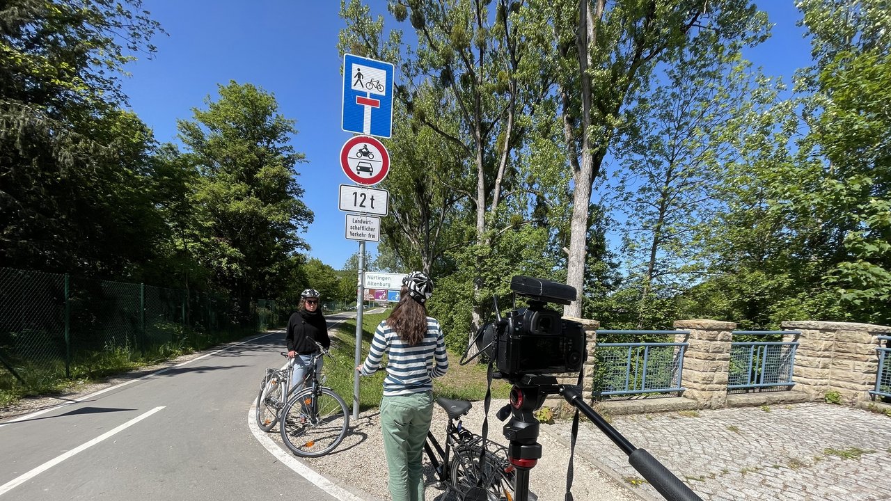 Interview der Radwegbeauftragten, Man sieht Tanja Idler mit einem Fahrrad gegenüber Frau Bierbaum stehen. Beide befinden sich auf einem Radweg.