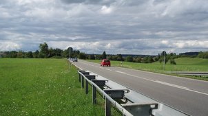 Eine Straße neben einer Wiese