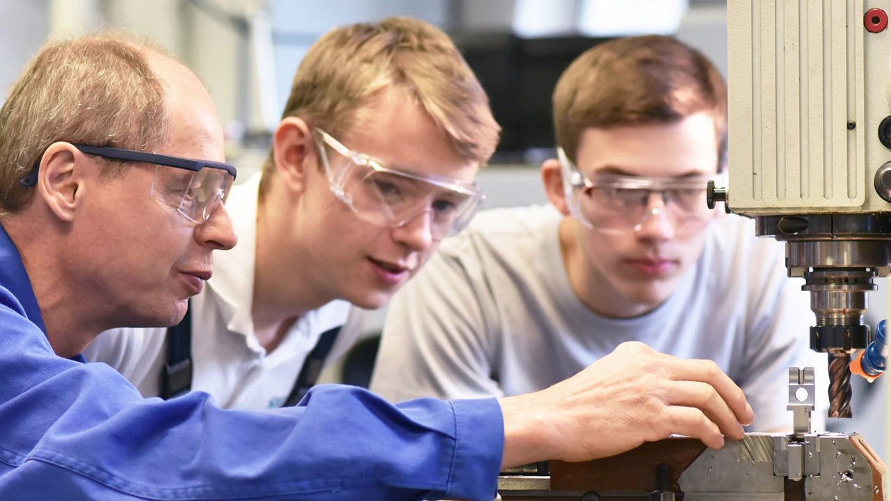 Gruppe junger Menschen in technischer Berufsausbildung mit Lehrer Gruppe junger Menschen in technischer Berufsausbildung mit Lehrer