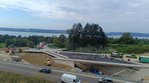 Das Bild zeigt die neue Brücke. Auf der Brücke wird gearbeitet, am Anfang und am Ende ist die Straße noch nicht ganz angebaut. 