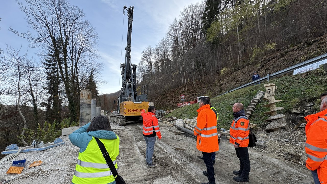 Das Foto zeigt ein Großbohrgerät an der Sirchinger Steige und mehrere Personen u. a. Regierungspräsident Klaus Tappeser bei der Besichtigung der Baustelle.