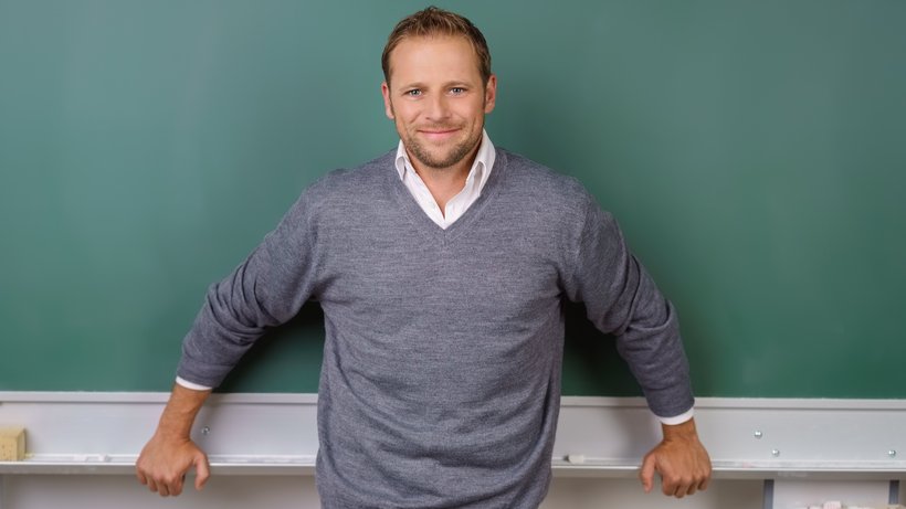 Lächelnder Lehrer vor der Tafel