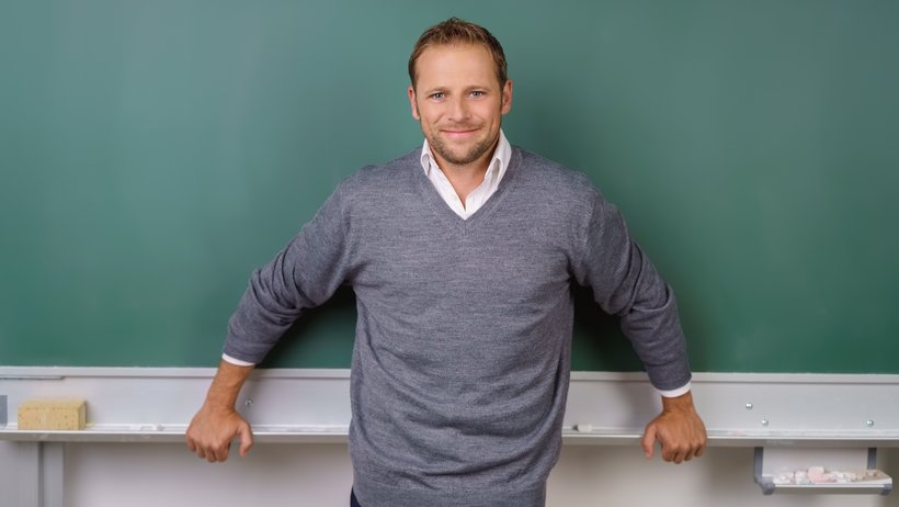 Lächelnder Lehrer vor der Tafel