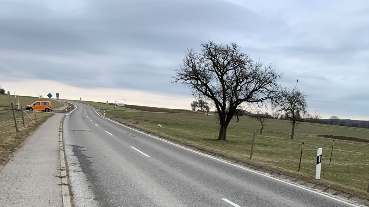 Blick auf eine Landesstraße, die den Berg hinaufführt. Oben links im Bild sieht man ein Fahrzeug der Straßenbauverwaltung.