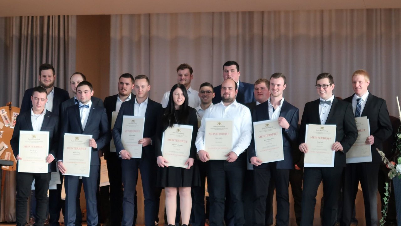 Das Bild zeigt ein Gruppenbild mit einer Landwirtschaftsmeisterin und mehreren Landwirtschaftsmeistern mit Ihren Urkunden in den Händen