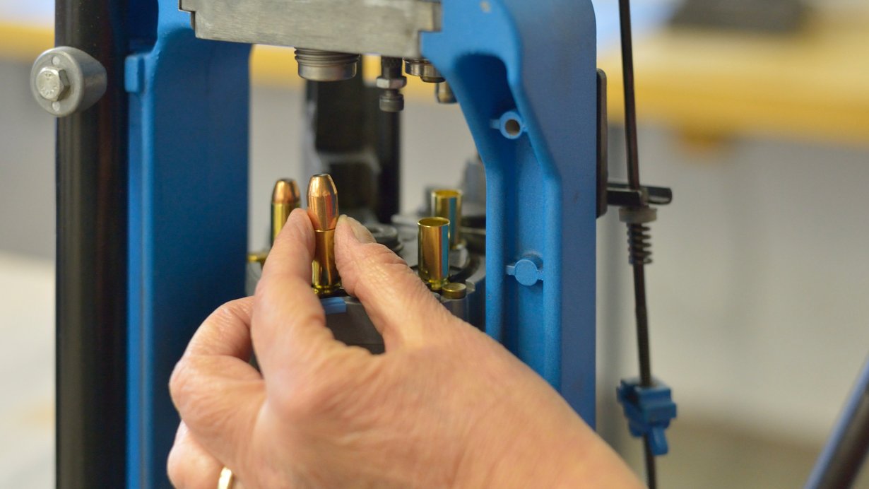 Munitionskontrolle; eine Hand hält eine Munition und stellt sie in das Gerät, welches die Kontrolle durchführt