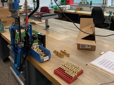 ein Arbeitsplatz, auf dem Patronen zur technischen Prüfung liegen