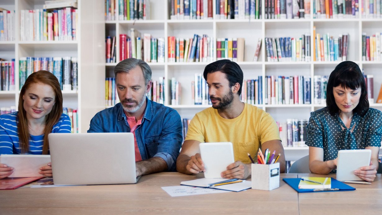 Lehrerinnen und Lehrer verschiedener Fachrichtungen sitzen am Tisch