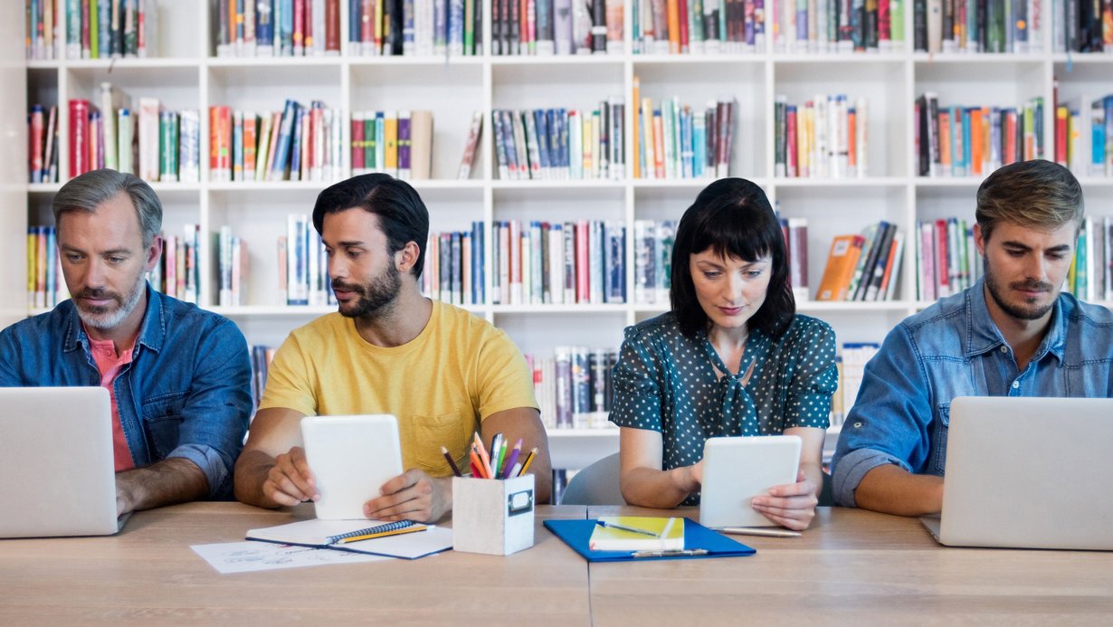 Lehrerinnen und Lehrer verschiedener Fachrichtungen sitzen am Tisch