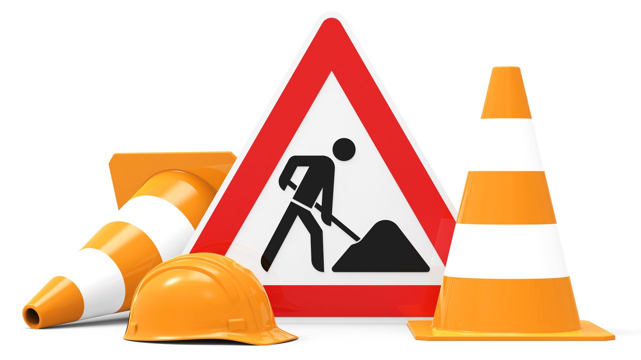 Baustellenschild, Baustellenhelm und zwei Pylonen