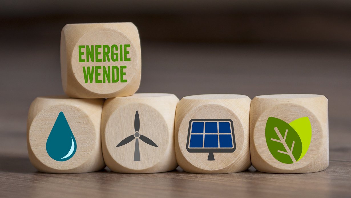 Symbolbild Energiewende; verschiedene Würfel liegen auf dem Tisch und zeigen Symbole für Windktaft, Wasserkraft, Solarenergie, Erdwärme und Biomasse