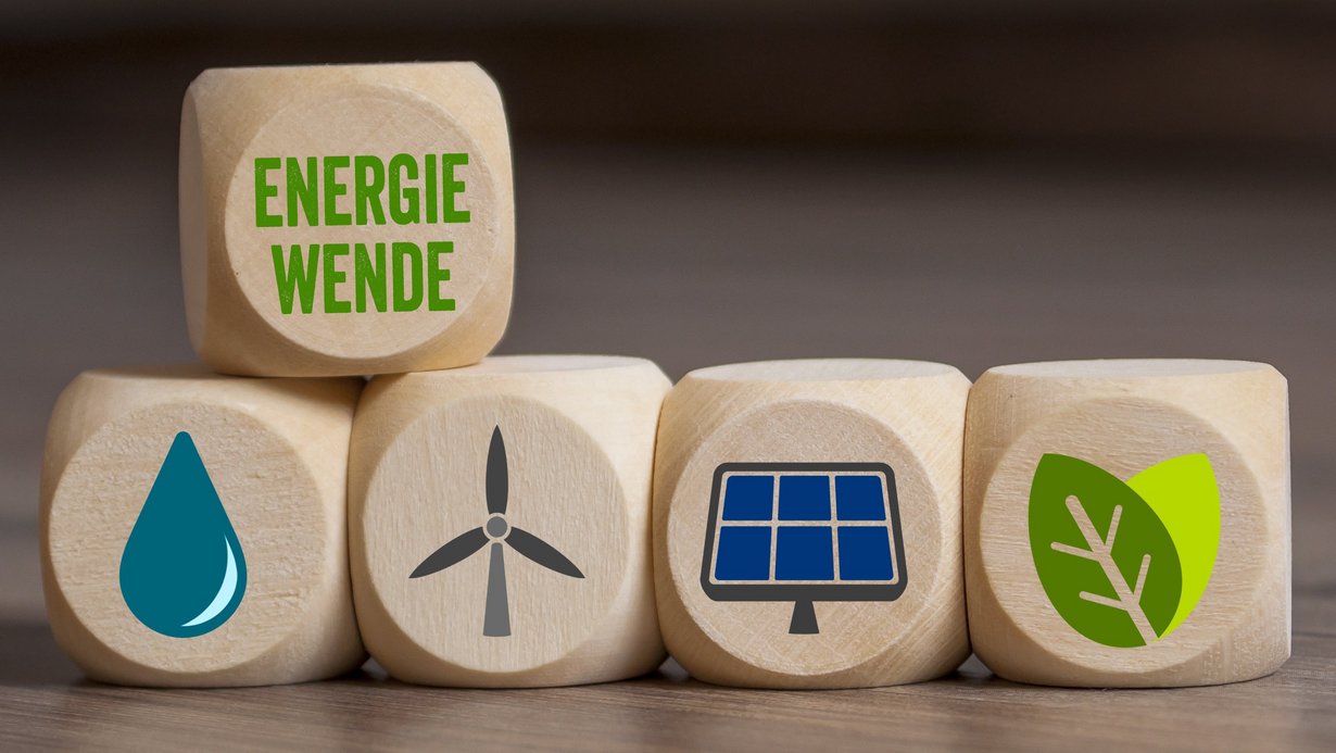 Symbolbild Energiewende; verschiedene Würfel liegen auf dem Tisch und zeigen Symbole für Windktaft, Wasserkraft, Solarenergie, Erdwärme und Biomasse
